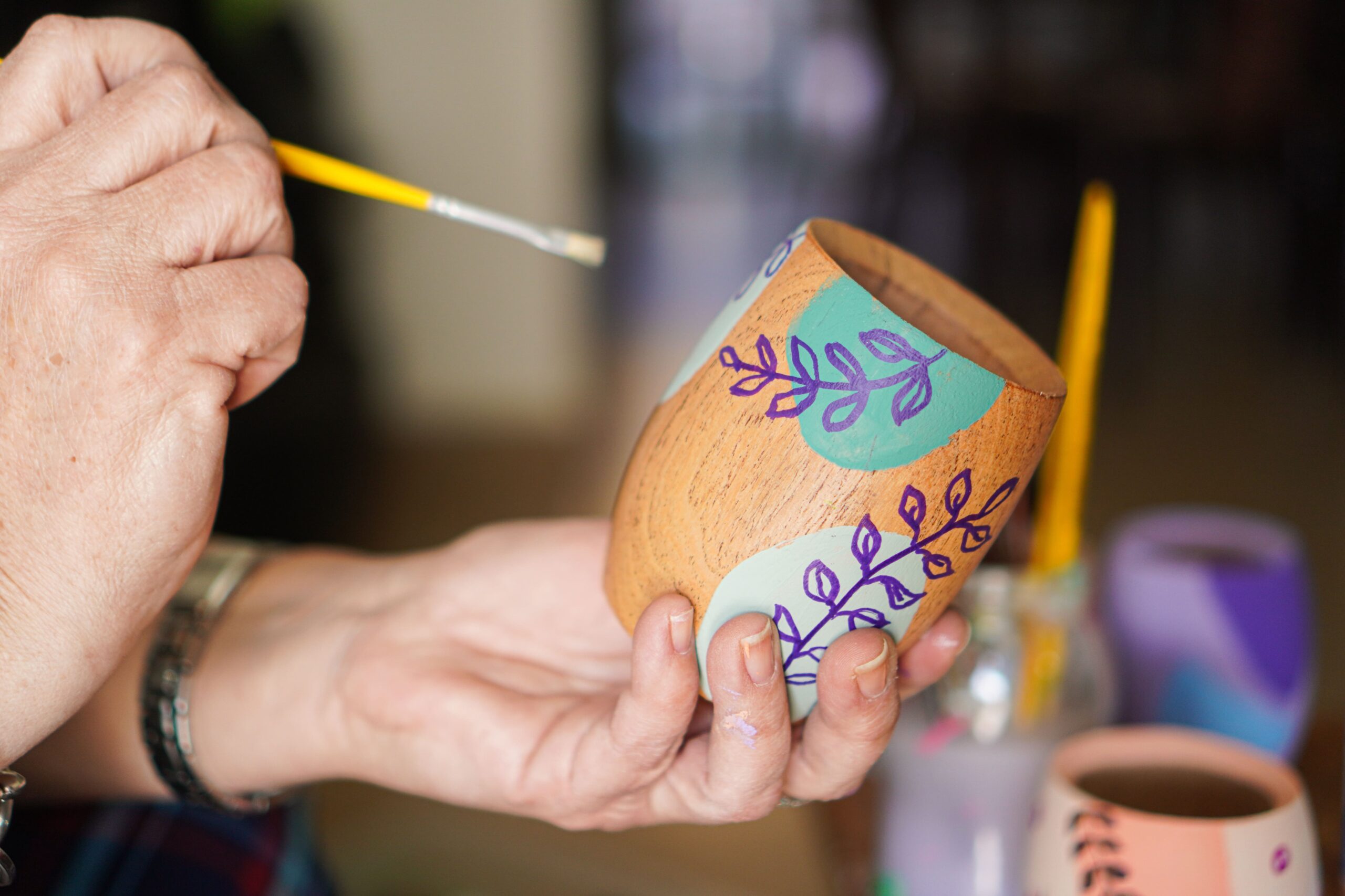 Artesano pintando un vaso de mate artesanal