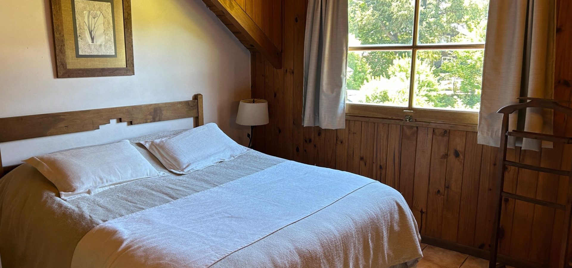 Cama cómoda y acogedora en la habitación de un apartamento de Las Cumbres Apart & Suites, brindando un espacio tranquilo y confortable para descansar durante tu estadía en San Martín de los Andes
